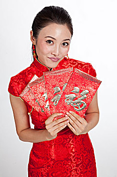 棚拍身穿中国传统服装的年轻女人展示利市封