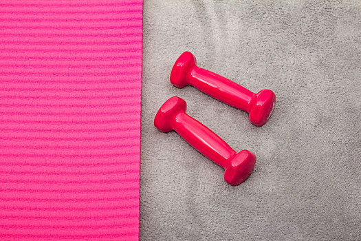 女生使用粉红色哑铃锻炼手部力量