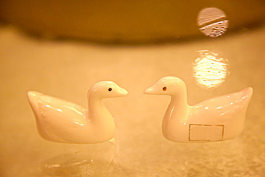 两只陶瓷制作的鸭型筷子托对视