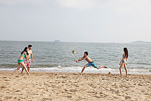 时尚青年人海边沙滩排球
