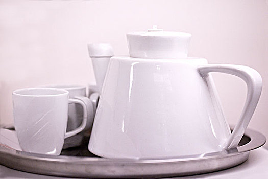 一套白色的陶瓷茶具放在托盘中