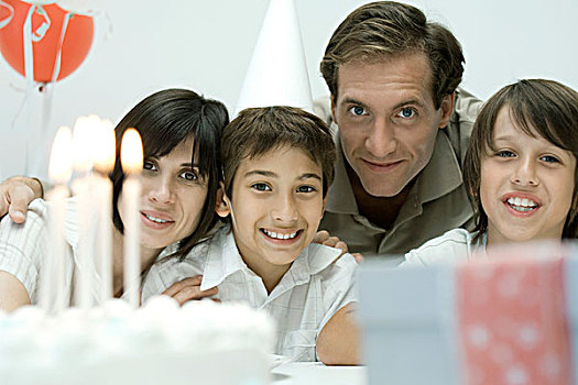 家庭,正面,生日蛋糕,照亮,蜡烛,看镜头,微笑
