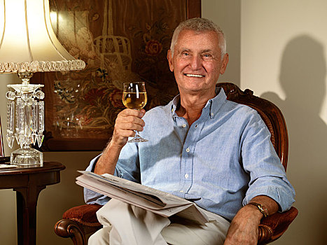 老人,坐,椅子,报纸,葡萄酒杯,手