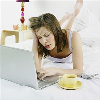 女人,床上,用电脑,茶杯,手机