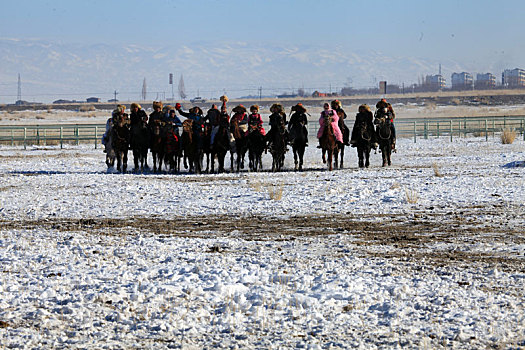 新疆巴里坤,冬日里盛装的哈萨克族的马背上的运动