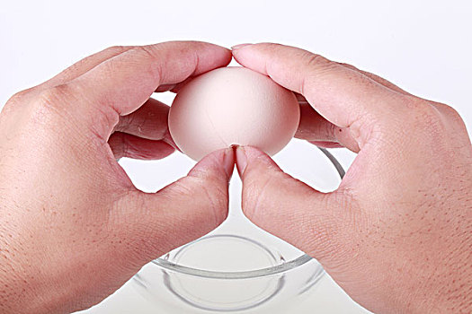 两只手给玻璃碗里打鸡蛋