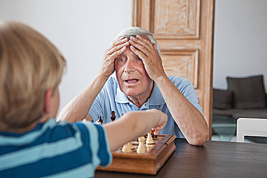惊奇,老人,手抱头,看,孙子,玩,下棋,在家