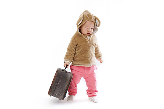 儿童提着行李箱去旅行