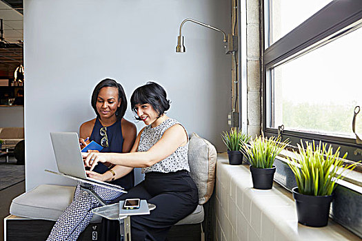 两个女人,坐,工作,笔记本电脑,站立