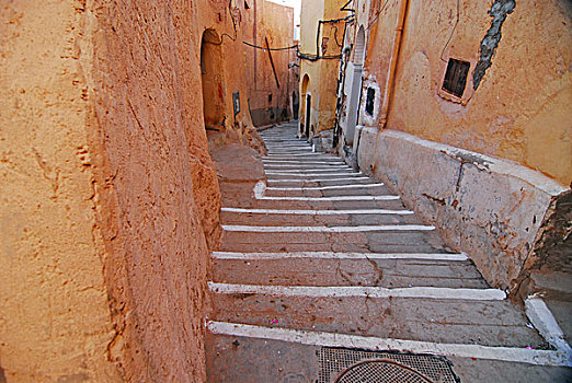 algeria,ben,isguen,run-down,mud,brick,wall,with,an,arched,way,and,staircase