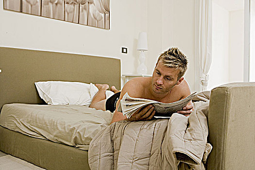 男青年,读报,床上