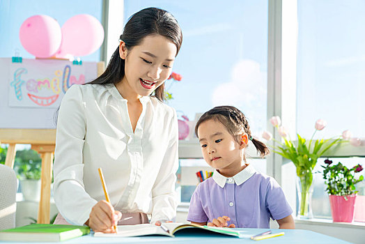 老師教小女孩讀書
