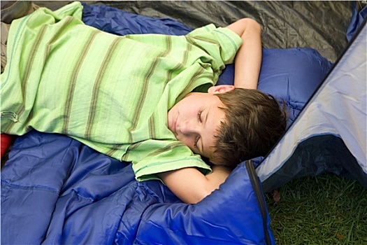 男孩,8-10岁,躺着,睡袋,帐蓬,入口,闭眼,睡觉,手放头后,侧面视角