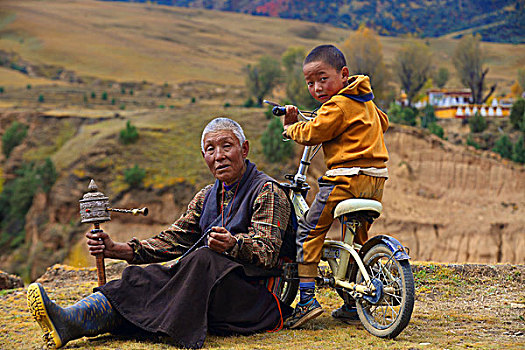 坐在草地上的西藏爷孙俩