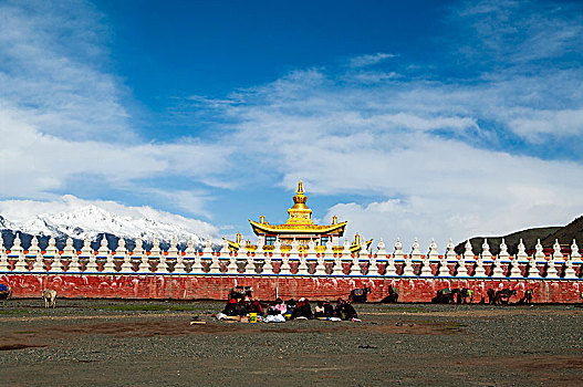金色屋顶藏族寺庙外的牧民