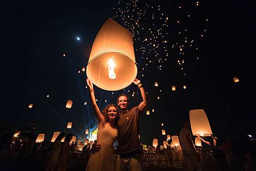 泰国清迈水灯节活动,一对情侣正在放飞点燃的天灯