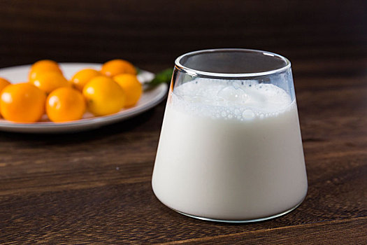 新鲜营养的牛奶喝美味好吃的金桔在木桌上