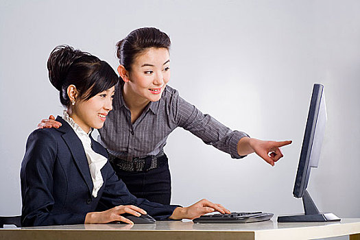 两个使用电脑的商务女青年