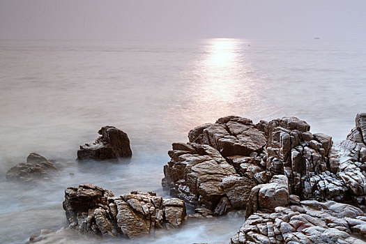 中国山东省日照市任家台海滨礁石公园早晨飘渺的海面风光