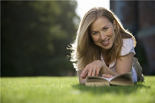 金发女郎,放松,草坪,花园,趴着,读,书本,微笑,正面,头像,贴地拍摄,聚焦