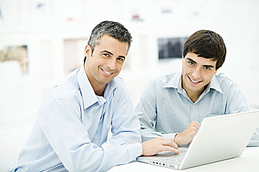 两个男人,使用笔记本,电脑,一起,看镜头,微笑