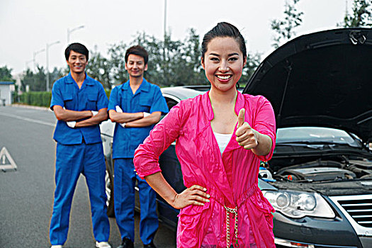 青年女人在路边修理汽车