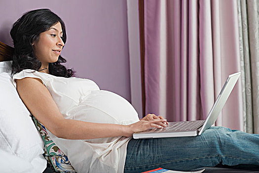 孕妇,笔记本电脑,床