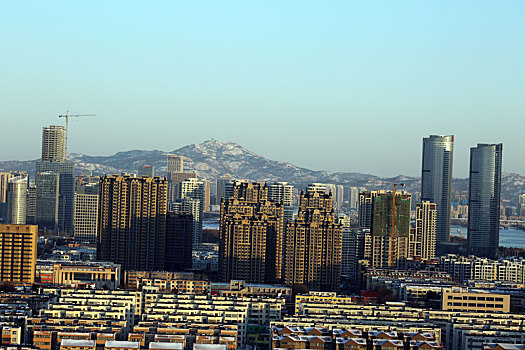 山东省日照市,雪后初晴的港城空气清新,高楼大厦与皑皑雪山相映成趣