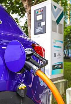 新能源汽车充电站的充电桩和正在充电的汽车特写