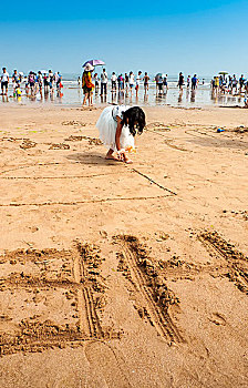 海滩上休闲玩耍作画的小女孩