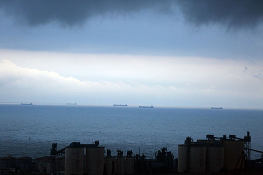 山东省日照市,海面上空阴云密布,万吨巨轮静泊锚地处变不惊