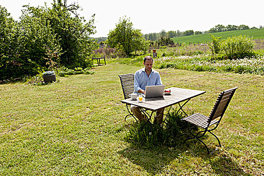 男人,坐,桌子,后院,早餐,笔记本电脑