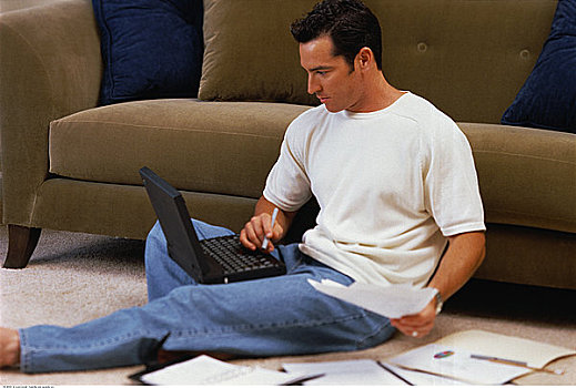 男人,坐,地板,靠近,沙发,使用笔记本,电脑