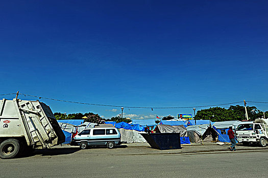 haiti,port,au,prince,trash,truck,in,front,of,tents,champ,de,mars,camp