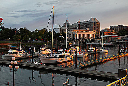 加拿大卑诗省省会所在地的维多利亚,从维多利亚港内港坝道上远眺,傍晚,港口披上金色的霞光,远处,霞光映照下的那座白色柱型建筑,维多利亚皇家伦敦蜡像馆熠熠生辉