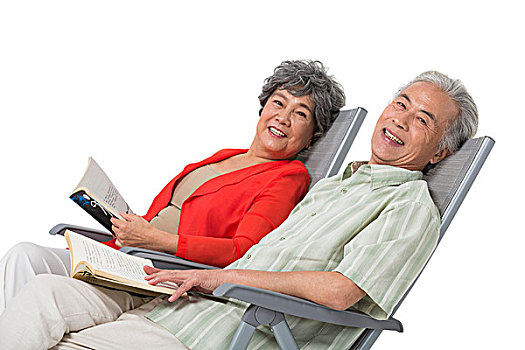 快樂的老年夫婦坐在沙灘椅上