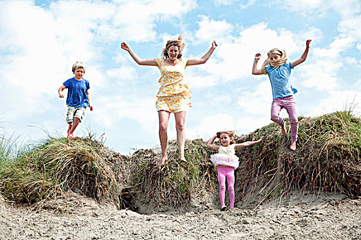 母亲,三个孩子,跳跃,沙丘,威尔士,英国