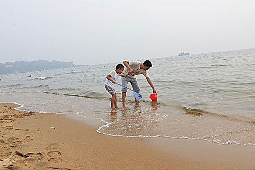 夏日大海边游玩的父子