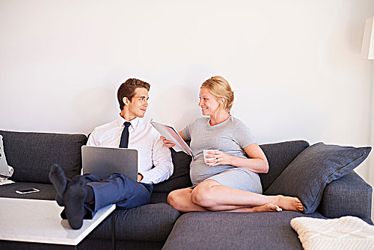 怀孕,坐,夫妇,沙发,杂志,笔记本电脑