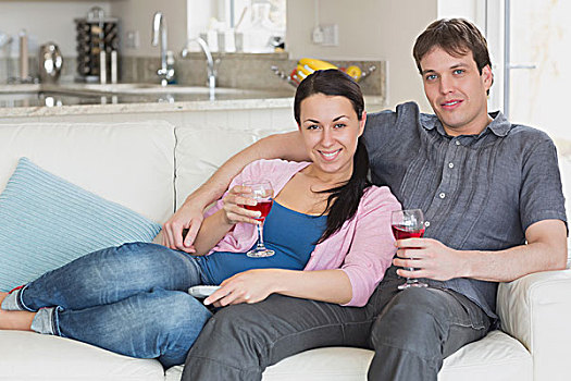 年轻,情侣,坐,沙发,客厅,喝,葡萄酒