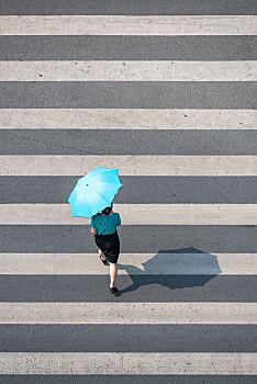 人行道上过路的打伞美女