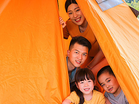 快乐的四口之家在帐篷里合影