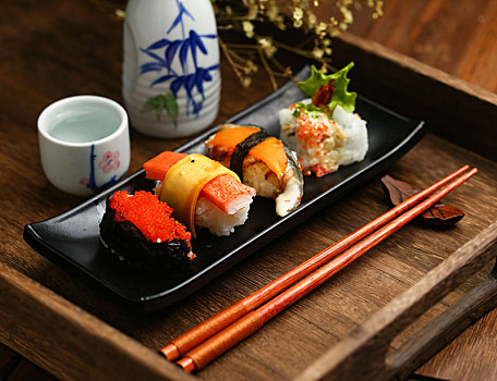 寿司拼盘和日本清酒放在木托盘里