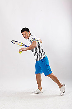一个穿休闲装打网球的青年男士