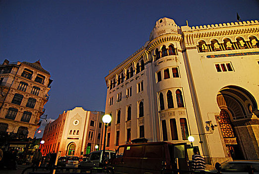 algeria,alger,low,angle,view,of,people,by,post,office,building,against,sky,at,dusk