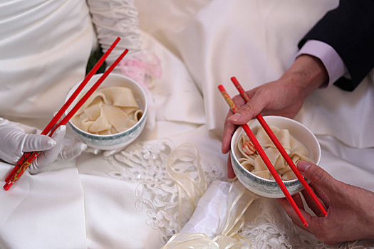 新娘新郎手持盛着喜饺的碗