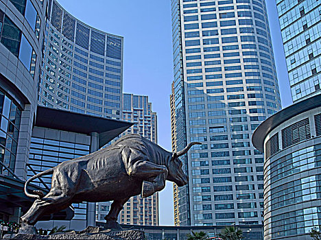 摩天大楼下的铜牛雕像