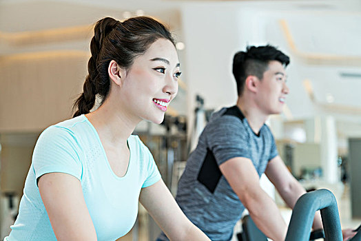 年轻男子和女子在健身房健身