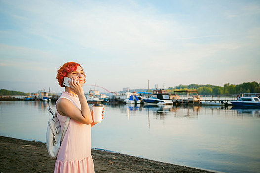女孩,苍白,粉红裙,红发,背包,走,河岸,通电话,喝咖啡,纸板,杯子,背景,泊船,温暖,夏天