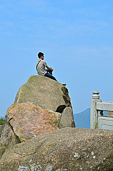 坐在石头上的游客